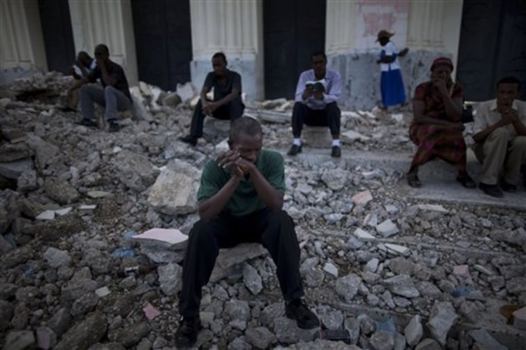 Catholics pray in the rubble of the Notre Dame cathedral during mass in Port-au-Prince, Haiti, Sunday Sept. 26, 2010.  Haiti was devastated by a magnitude-7 earthquake on Jan. 12, 2010 that killed a government-estimated 300,000 people and left millions homeless.  (AP Photo/Ramon Espinosa)